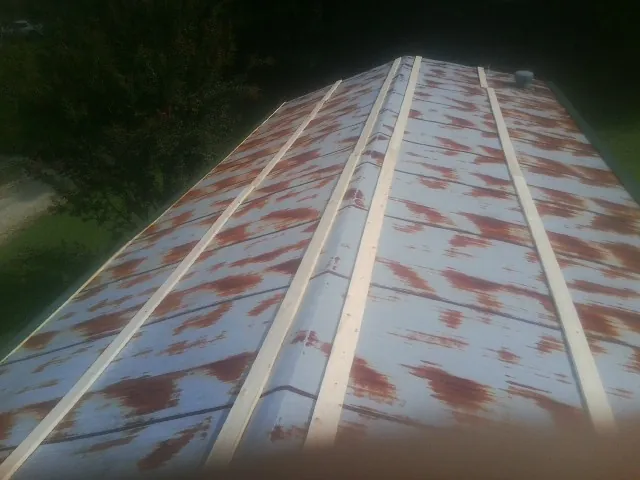 Rusted metal roof panels with new wood purlins before replacement — Storm Damage Roof Repair in Bowlus by Roofing Brothers