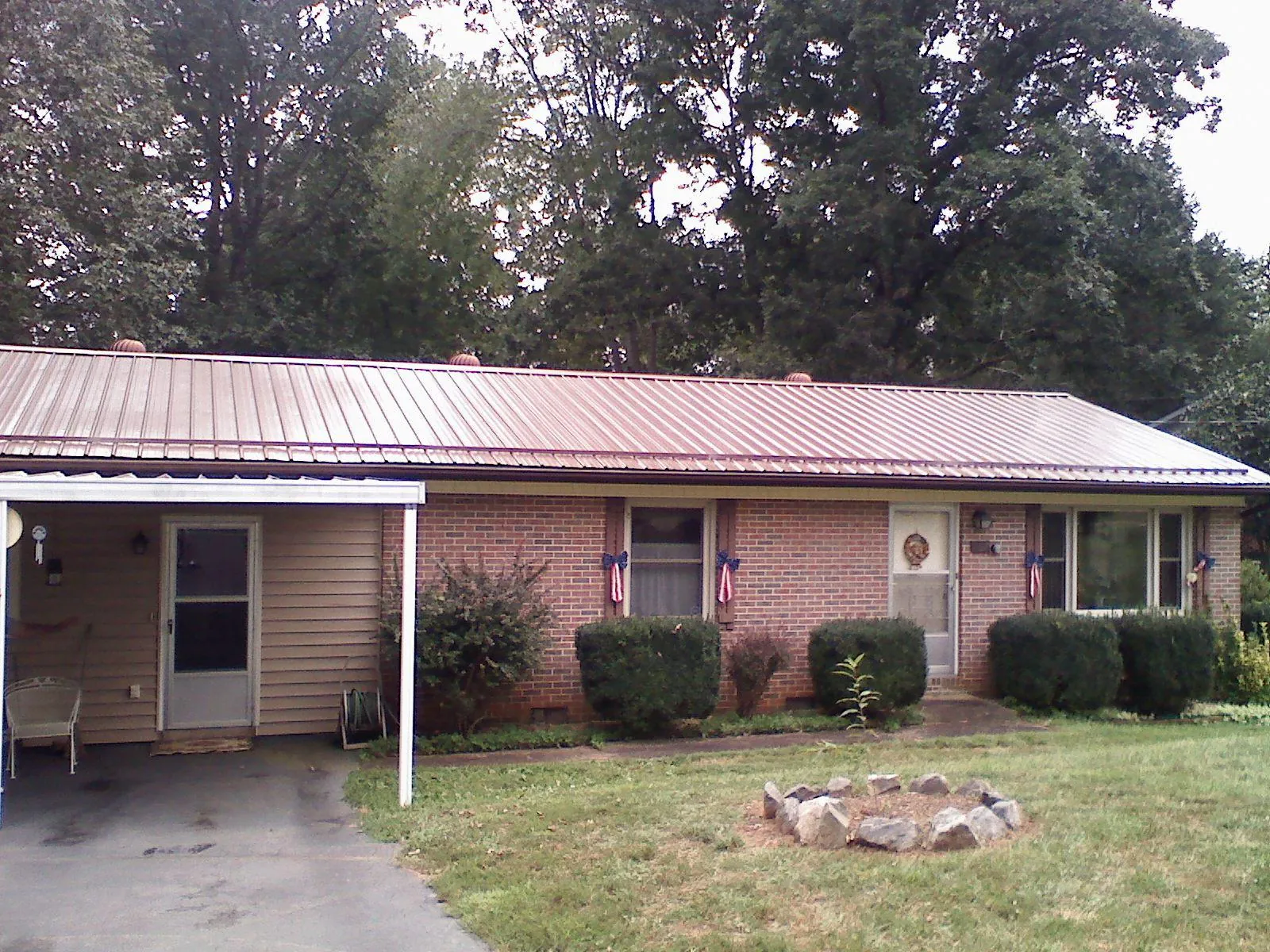 Bronze metal roof and carport on a brick ranch home — Roof Repair work by our crew in Bowlus